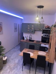 a kitchen with a wooden table and chairs in it at L&A Appartement in Montargis