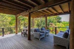eine Holzterrasse mit einem Tisch und Stühlen darauf in der Unterkunft Tree & Sea sleeps 11 in Point Lookout