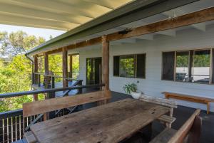 a porch with a wooden table and benches on it at Tree & Sea sleeps 11 in Point Lookout +20 photos