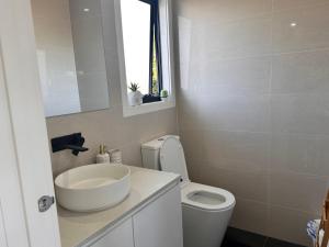 een badkamer met een wastafel en een toilet en een raam bij All you need for work, stay and relax in Melbourne