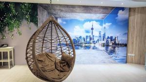 a cat sitting in a hanging hammock in a room with a city at Hotel Mapp in Taichung