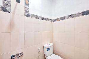 a white bathroom with a toilet in a room at RedDoorz at Hotel Lavender Kertajati in Gadel