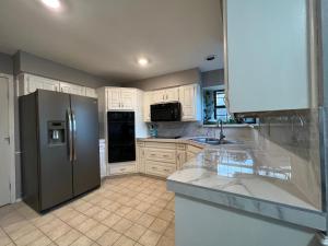 una cucina con mobili bianchi e un frigorifero in acciaio inossidabile di Private Room in Carrollton a Carrollton