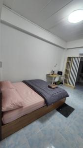 una camera da letto con un letto e una scrivania di หลังมอ บิวตี้ อพาร์ตเมนต์ เปลี่ยนชื่อเป็นหลังมอ อพาร์ทเมนท์สามสาว ห้องพักจะอยู่ในทาวเฮ้า2ชั้น เเจ้งเปลี่ยนที่พัก a Ban Hua Khwai