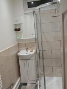 een badkamer met een douche en een wastafel bij PONDEROSA B&B with free onsite parking and breakfast included in Blackpool +51 foto's