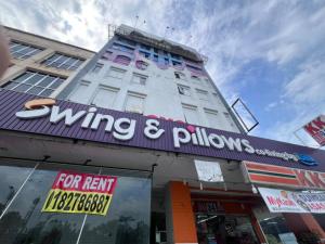 un bâtiment avec une enseigne indiquant « victoire » et des fenêtres dans l'établissement Swing & Pillows - Kajang, Selangor, à Kajang