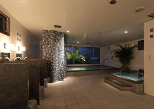 a large bathroom with a swimming pool in a building at Toyooka Green Hotel Morris in Toyooka