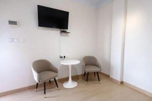 a room with two chairs and a table and a tv at Kanza Beach Inn in Marang