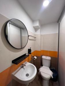 une salle de bain avec un lavabo et un miroir et des toilettes dans l'établissement Swing & Pillows - Kajang, Selangor, à Kajang