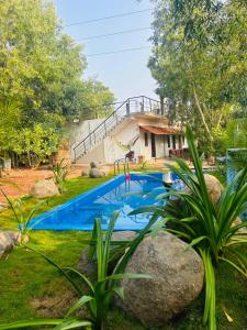 een huis met een zwembad in een tuin bij Cozy haven in Auroville