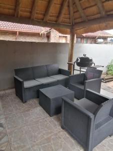 a patio with couches and a grill in the background at Imvumbu Guest House in Nelspruit
