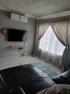 a living room with a couch and a large window at Imvumbu Guest House in Nelspruit