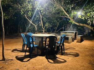 een tafel en stoelen in een park 's nachts bij Cozy haven in Auroville