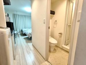 a bathroom with a toilet and a room with a bed at ティエラ北池袋 in Tokyo