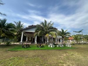 a building with tables and chairs in front of it at Kanza Beach Inn in Marang