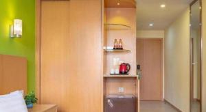 Zimmer mit einer Küche mit grünen Wänden in der Unterkunft Guangxin Hotel Shenzhen in Shenzhen