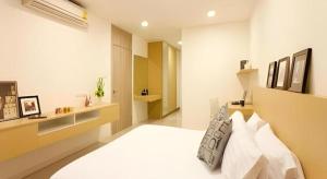 een slaapkamer met een groot wit bed met witte kussens bij Landmark Residence in Ban Khlong Sanam Phli