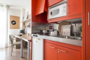 a kitchen with red cabinets and a sink at Residencia Universitaria Resa Manuel Agud Querol in San Sebastián