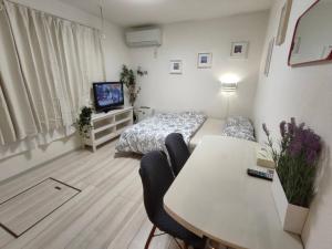 a living room with a table and a bed and a television at ティエラ北池袋 in Tokyo
