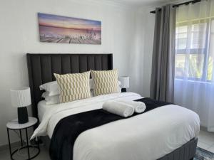 a bedroom with a large bed with yellow and white pillows at 2 Bedroom Condo in Sunninghill Sandton in Sandton