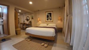 a bedroom with a bed with white sheets and slippers at Apartments by Karma Artful Retreat in Patan Durbar Square in Pātan