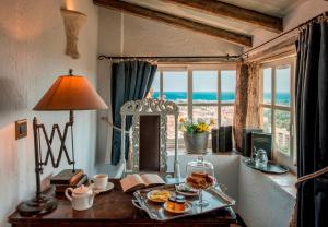 una mesa con una bandeja de comida en ella con una ventana en Château Le Cagnard en Cagnes-sur-Mer