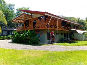 a house with a balcony on top of it at Domi Hostel in Dominical