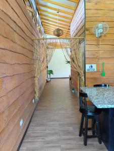 a hallway in a house with wooden walls and a table at Domi Hostel in Dominical +24 photos