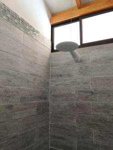 a bathroom with a stone shower with a window at Domi Hostel in Dominical
