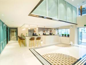 twee mannen in de keuken van een huis bij Magnotel Harbin Songbei Wanda Wenlvcheng in Harbin