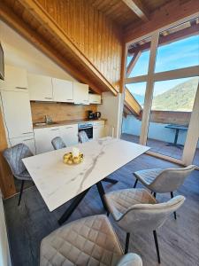 een keuken met een grote witte tafel en stoelen bij MonteVita Pitztal Panorama Apartments 
