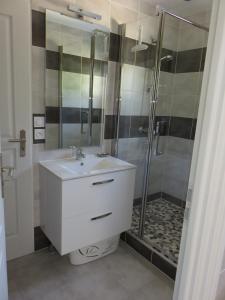 a bathroom with a sink and a shower at La petite maison in Malataverne