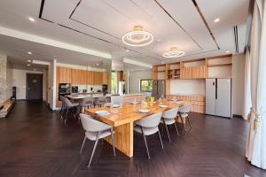a kitchen and dining room with a long wooden table and chairs at Villa Lion Phuket in Phuket