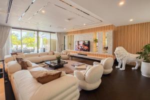 a living room with white furniture and a white lion statue at Villa Lion Phuket in Phuket
