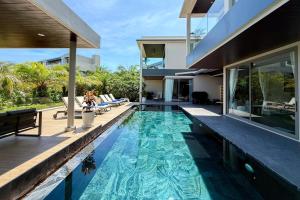 an infinity pool in the backyard of a house at Villa Lion Phuket in Phuket