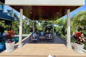 a covered deck with chairs and a swimming pool at Villa Lion Phuket in Phuket