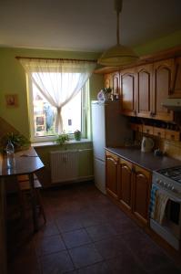 卡利什的住宿－Apartament Rodzinny w Kaliszu，厨房配有冰箱、桌子和窗户。