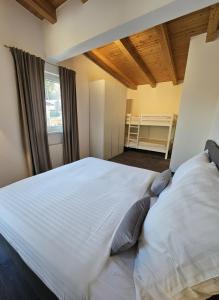 een groot wit bed in een kamer met een raam bij MonteVita Pitztal Panorama Apartments  +42 foto's