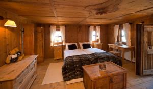 カンポ・トゥーレスにあるMountain Chalet Obertreyenのログキャビン内のベッドルーム1室(大型ベッド1台付)