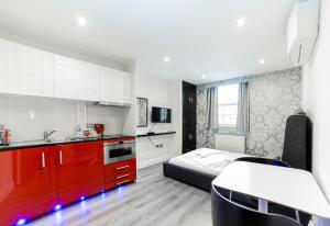 a kitchen and a bedroom with a bed and a kitchen at Imperial Court Suites in London