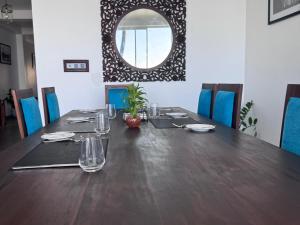 a long table with chairs and a mirror on the wall at Florain Otium Talpe - 3 Bedroom Oceanfront Villa in Unawatuna