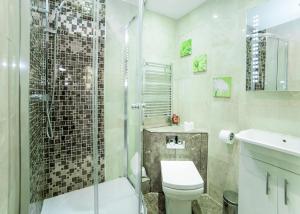 a bathroom with a shower and a toilet and a sink at Imperial Court Suites in London