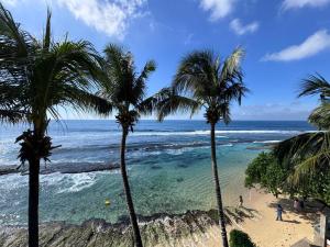 a group of palm trees on a beach with the ocean at Florain Otium Talpe - 3 Bedroom Oceanfront Villa in Unawatuna