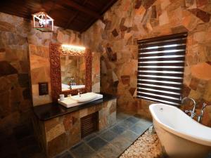 a bathroom with a tub and a sink and a mirror at Florain Otium Talpe - 3 Bedroom Oceanfront Villa in Unawatuna +10 photos