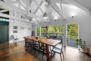 Un comedor con mesa y sillas de madera. en HUs - Boutique Venue & Accommodation, en Riverhead