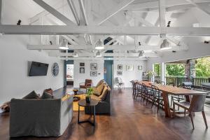 Una sala de estar con sofás, mesas y sillas. en HUs - Boutique Venue & Accommodation, en Riverhead