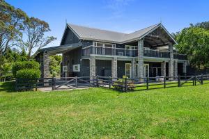 una gran casa negra con un patio verde en HUs - Boutique Venue & Accommodation, en Riverhead