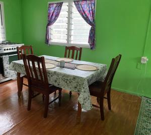 un tavolo da pranzo con sedie, un tavolo e una finestra di Mana ki he Mana Residence 