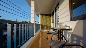 een balkon met een tafel en stoelen erop bij Three Monkeys Mae Nam beach in Nathon Bay
