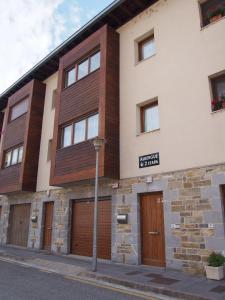 a building with wooden doors on a street at Albergue Segunda Etapa in Zubiri